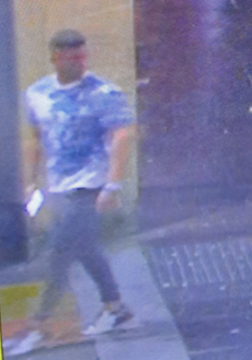 CCTV showing showing white male with short dark hair in blue patterned t-shirt