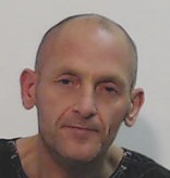 Man with bald head wearing dark coloured top