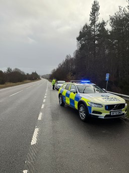 Police Scotland vehicle at the side of the A9 in front of a white car.