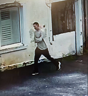 16-yr-olf white male on CCTV image walking down street wearing a beige jumper and black trousers