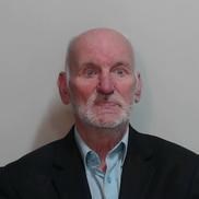 Image of man sentenced, Brian Stobie - White man in 70s with white beard and bald head wearing a light blue shirt and dark coloured jacket