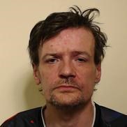 man with dark hair wearing a dark coloured top