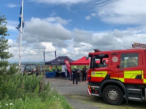 Image of fire engine in the foreground with police, fire service and motorcyclists in the background.
