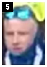 White man of slim build with short blonde hair and was wearing a black t-shirt with white writing across the chest, a blue snood and blue mirrored sunglasses