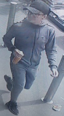 14-year-old white boy with glasses. Wearing a grey tracksuit and a black baseball cap and trainers