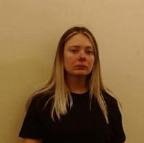 21-year-old woman with long, fair hair wearing a dark coloured top