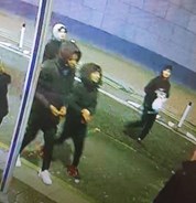 CCTV image of four males in black jackets