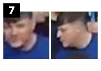 White man of medium build, has dark brown hair which is longer at the fringe. He is wearing a royal blue t-shirt with white letters across the chest