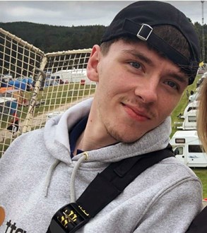 18-year-old man wearing black hat backwards and a grey hoodie