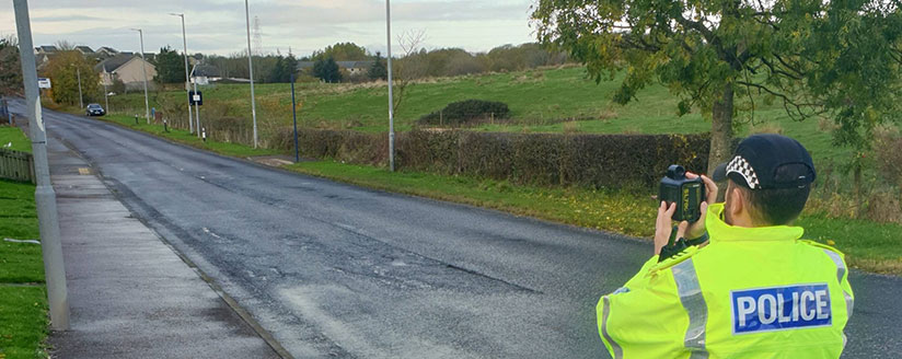 Officer on country road holding camera