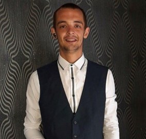 26-year-old man with short dark hair wearing white shirt and dark coloured waistcoat