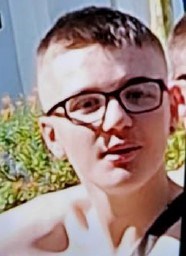 14-year-old white boy with brown short hair and wearing black framed glasses