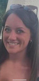 Image of missing woman Chelsea Woods- white woman in 20s, smiling with long dark hair, wearing silver hoop earrings and sunglasses on her head.