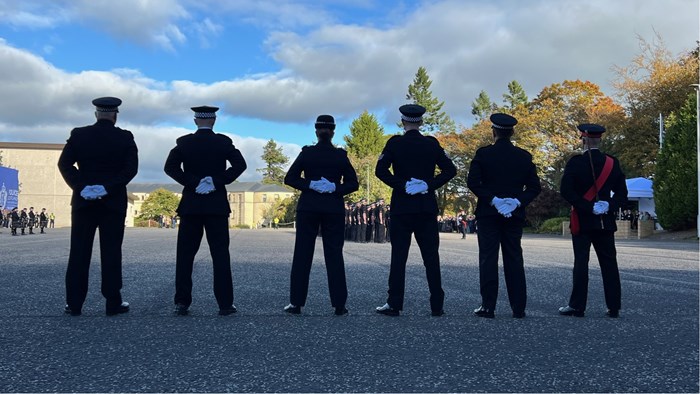 Officers stand to attention awaiting probationers being marched onto parade square